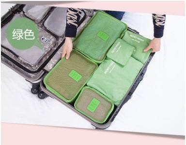 Green nylon packing cube travel organizers arranged in a suitcase.