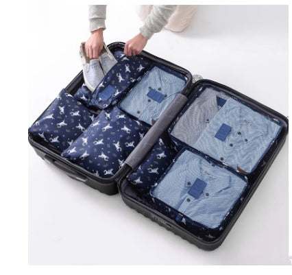 Navy blue nylon packing cubes in suitcase, organizing clothes neatly.