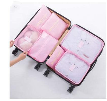 Pink durable waterproof nylon packing cubes organizing clothes in a suitcase.