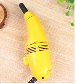 Yellow mini computer keyboard vacuum cleaner on wooden surface.