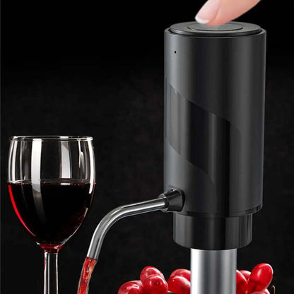 Black electric wine aerator and decanter pump beside a glass of red wine with grapes in the background.